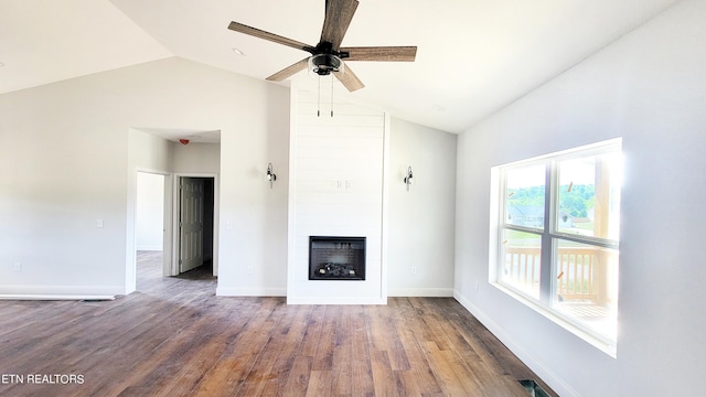 unfurnished living room featuring lofted ceiling, a large fireplace, ceiling fan, and dark hardwood / wood-style flooring