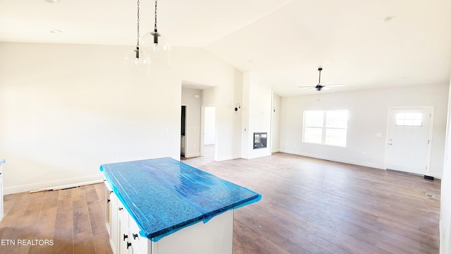 kitchen with ceiling fan, white cabinets, lofted ceiling, and light hardwood / wood-style floors