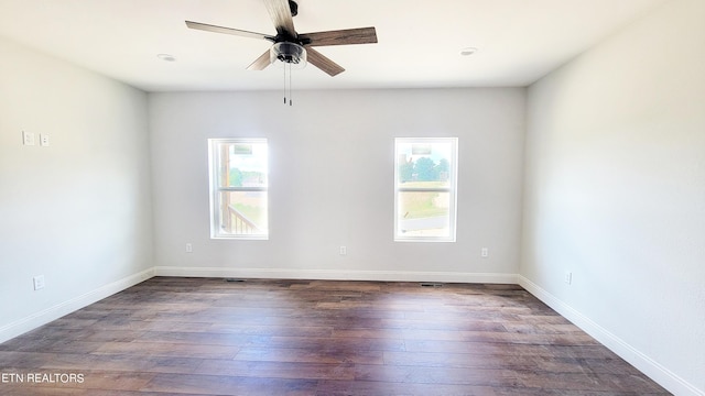 unfurnished room with a healthy amount of sunlight, dark hardwood / wood-style flooring, and ceiling fan