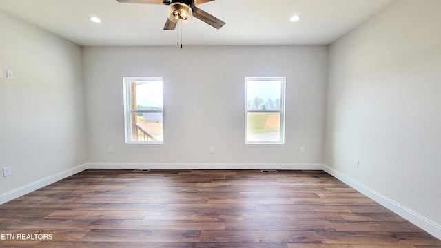 empty room featuring baseboards, dark wood finished floors, and recessed lighting