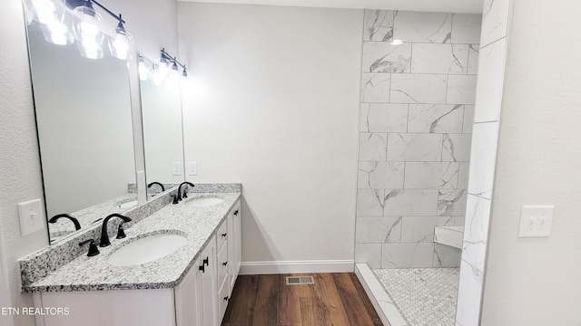 bathroom with a walk in shower, wood finished floors, a sink, and visible vents