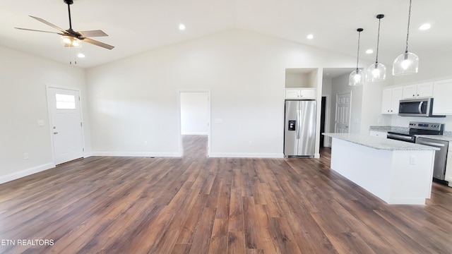 kitchen with open floor plan, stainless steel appliances, dark wood finished floors, and a center island