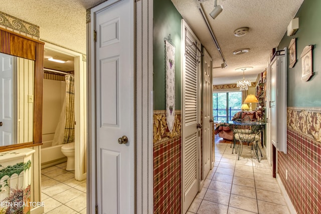1081 Cove Rd Unit 1012, Sevierville, TN 37876 - hall with a textured ceiling, wallpapered walls, light tile patterned flooring, and a chandelier