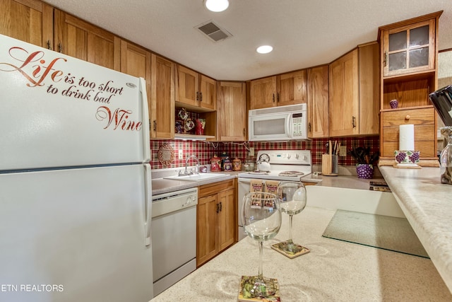 1081 Cove Rd Unit 1012, Sevierville, TN 37876 - kitchen with white appliances, light countertops, decorative backsplash, brown cabinetry, and recessed lighting