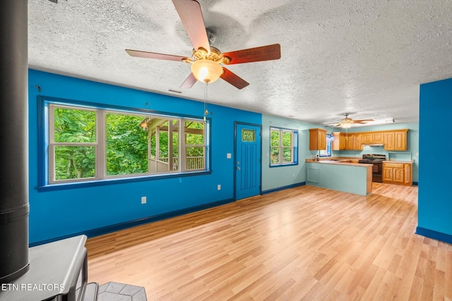 unfurnished living room with a textured ceiling and light hardwood / wood-style flooring