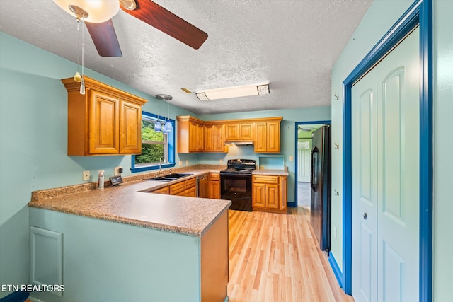 kitchen with light hardwood / wood-style floors, ceiling fan, a textured ceiling, black appliances, and sink