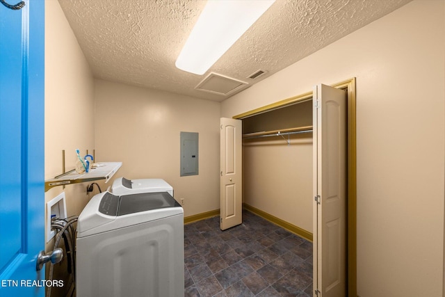 laundry area featuring a textured ceiling, separate washer and dryer, and electric panel