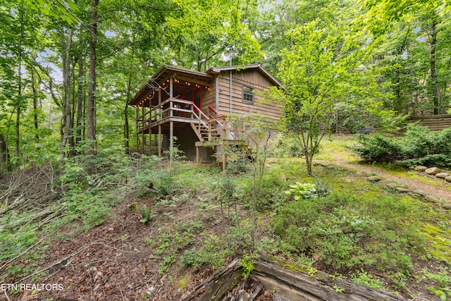 rear view of house featuring a wooden deck