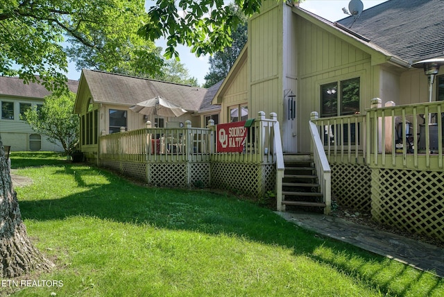 rear view of house with a yard and a wooden deck