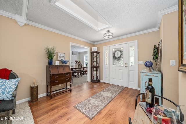 foyer entrance featuring hardwood / wood-style flooring, crown molding, and a textured ceiling