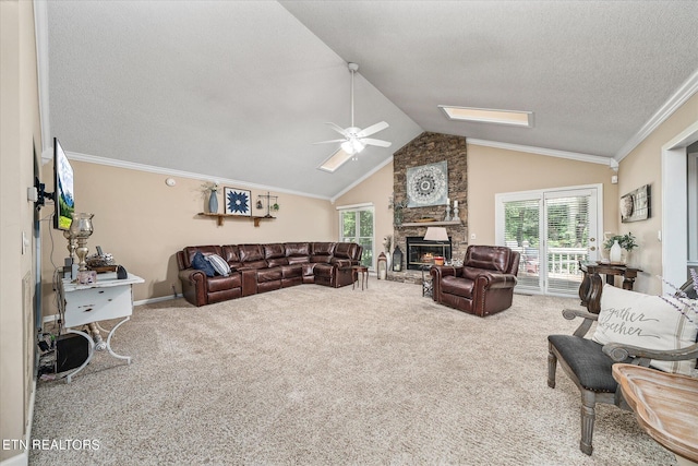 living room featuring lofted ceiling, ceiling fan, ornamental molding, a fireplace, and carpet floors