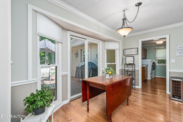 dining space with crown molding, light hardwood / wood-style flooring, a textured ceiling, and independent washer and dryer