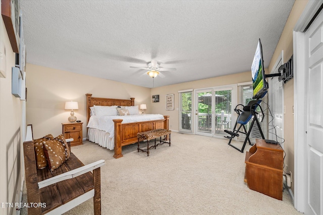 bedroom with access to exterior, a textured ceiling, light colored carpet, and ceiling fan