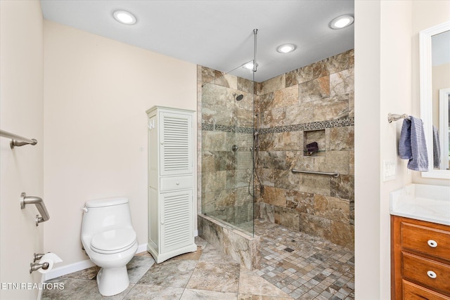 bathroom featuring tiled shower, vanity, and toilet