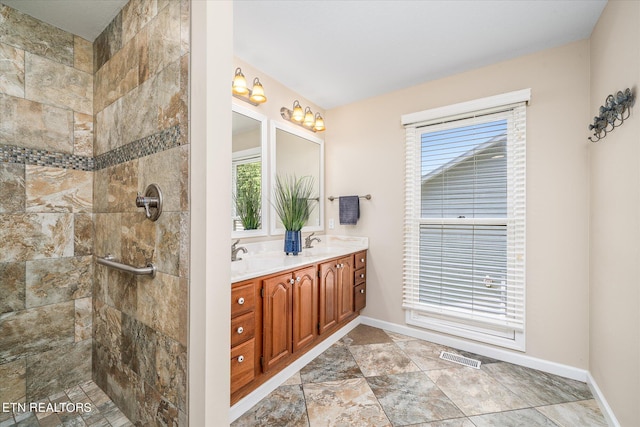 bathroom with vanity and tiled shower