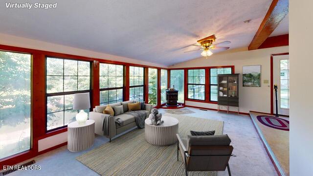 living room featuring carpet, ceiling fan, lofted ceiling with beams, and plenty of natural light