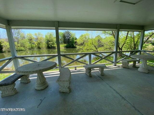 unfurnished sunroom featuring a water view