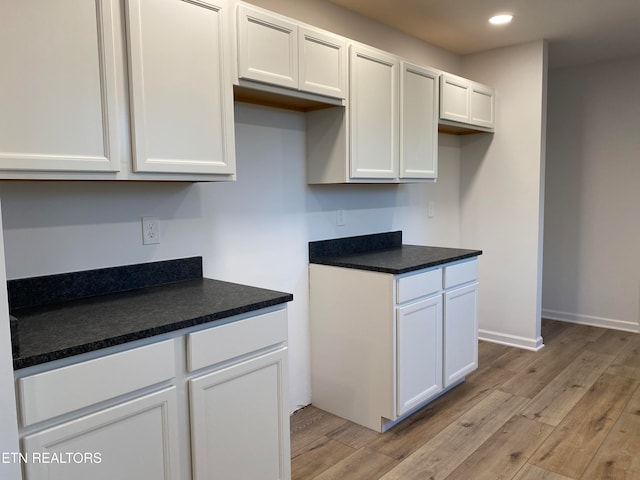 kitchen with white cabinets and light hardwood / wood-style floors