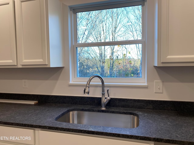 kitchen featuring white cabinetry and sink