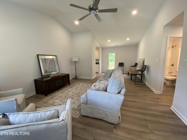 living area featuring baseboards, wood finished floors, a ceiling fan, and lofted ceiling