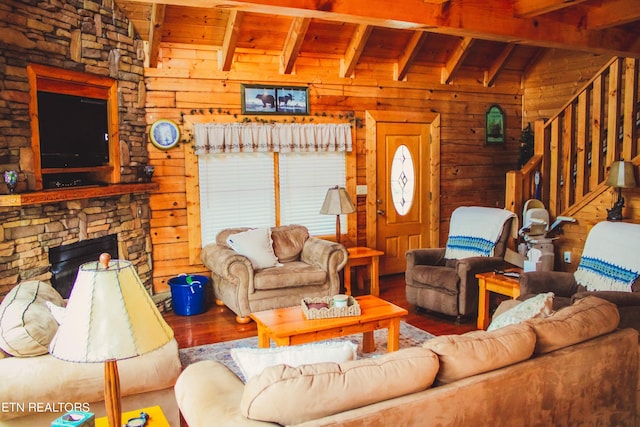 living room featuring hardwood / wood-style floors, wood ceiling, a fireplace, wood walls, and lofted ceiling with beams