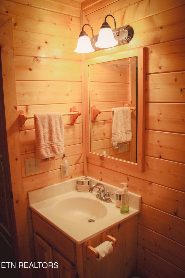 bathroom with vanity and wood walls