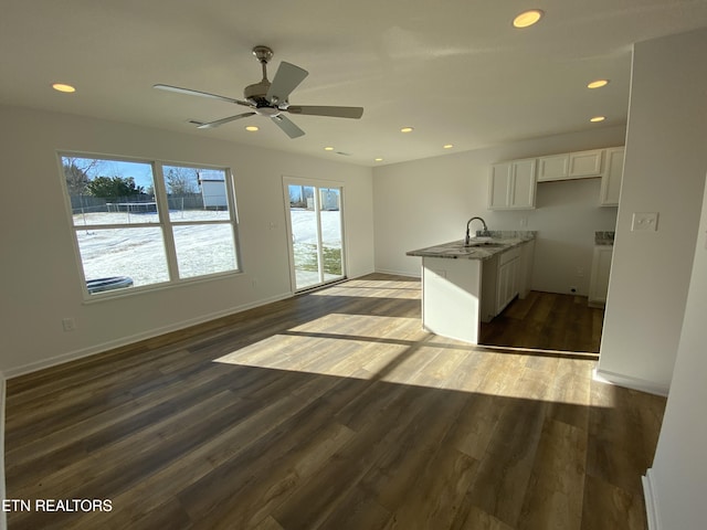 kitchen with sink, dark hardwood / wood-style floors, ceiling fan, stone countertops, and white cabinetry