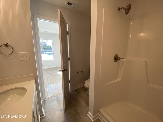 bathroom with toilet, vanity, and walk in shower