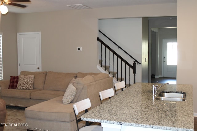 living room featuring ceiling fan and sink