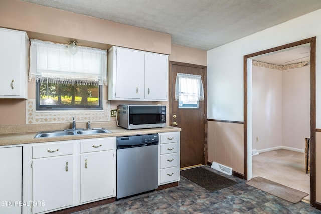 kitchen featuring appliances with stainless steel finishes, sink, and white cabinets