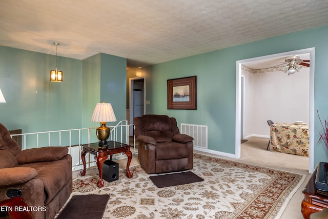 living room with carpet, a textured ceiling, and ceiling fan