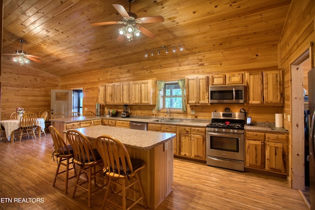 kitchen with vaulted ceiling, stainless steel appliances, a breakfast bar area, wooden ceiling, and sink