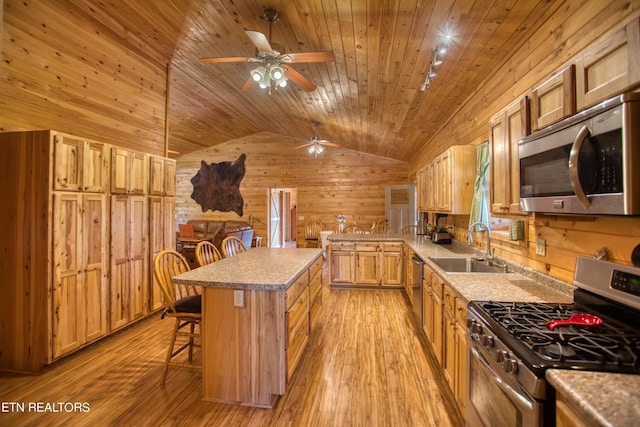 kitchen featuring wooden ceiling, appliances with stainless steel finishes, a center island, a kitchen bar, and lofted ceiling