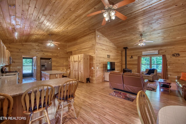 dining space featuring vaulted ceiling, wood ceiling, light hardwood / wood-style flooring, wood walls, and a wall mounted air conditioner