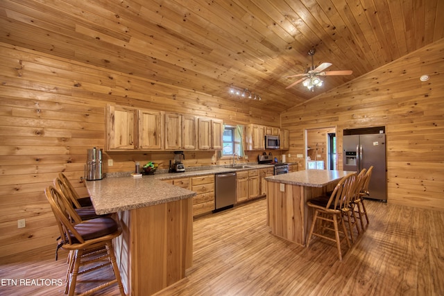 kitchen with stainless steel appliances, lofted ceiling, a kitchen breakfast bar, and sink