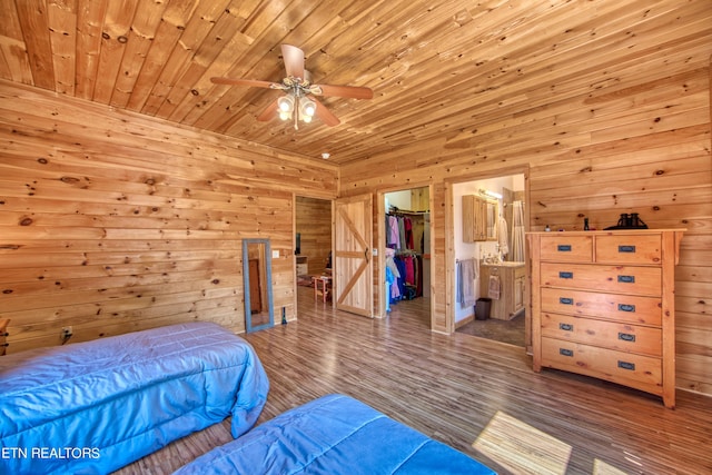 bedroom featuring wooden ceiling, a closet, wood-type flooring, a spacious closet, and wooden walls