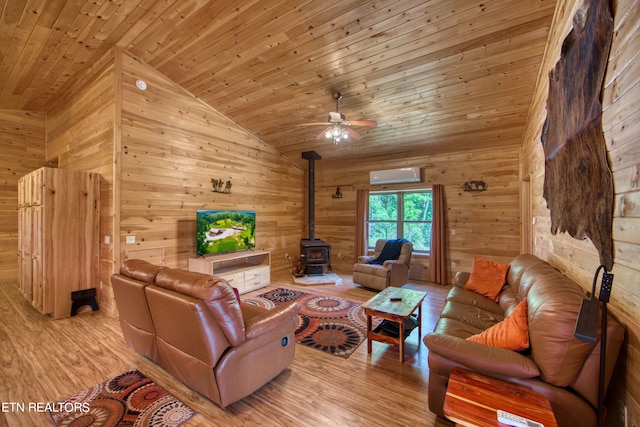 living room featuring an AC wall unit, wood walls, light hardwood / wood-style floors, wood ceiling, and a wood stove