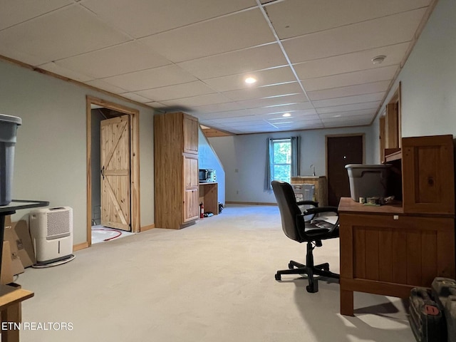 carpeted home office with a drop ceiling