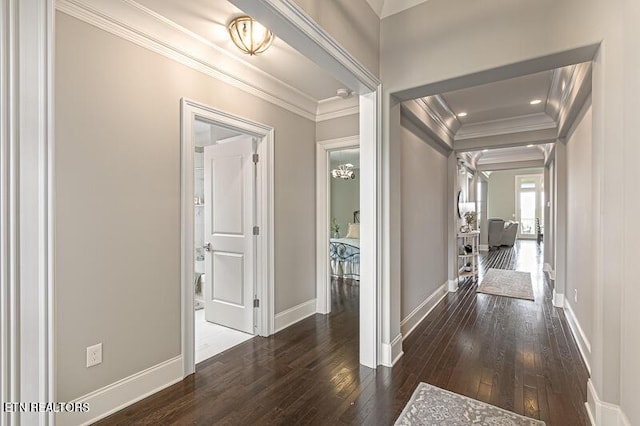 hall with dark wood-type flooring and ornamental molding