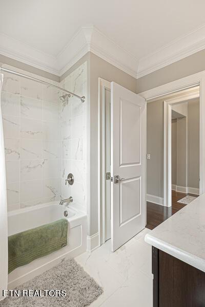 bathroom with vanity, crown molding, and tiled shower / bath