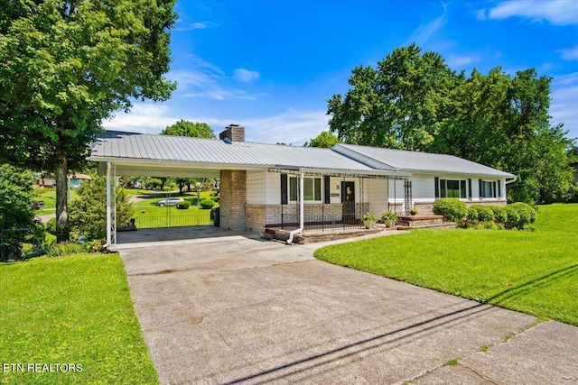 ranch-style home featuring a front lawn and a carport