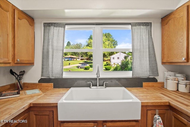 kitchen with a wealth of natural light, butcher block counters, and sink