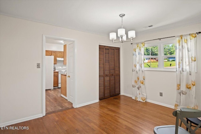 foyer with a notable chandelier, crown molding, and light hardwood / wood-style flooring