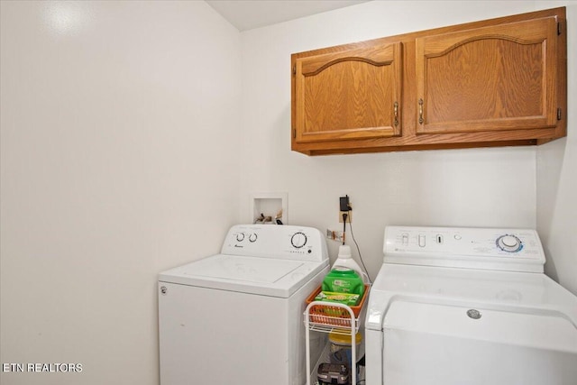 laundry room featuring cabinets and washer and clothes dryer