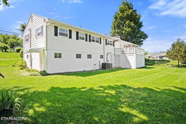 rear view of house featuring a lawn and central air condition unit