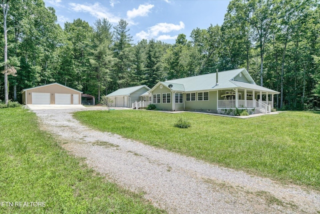 view of front of property featuring a porch, a front lawn, a garage, and an outbuilding