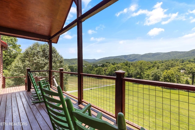 wooden deck featuring a lawn and a mountain view