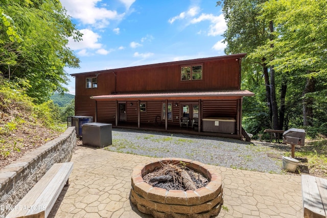 rear view of house featuring an outdoor fire pit and a patio