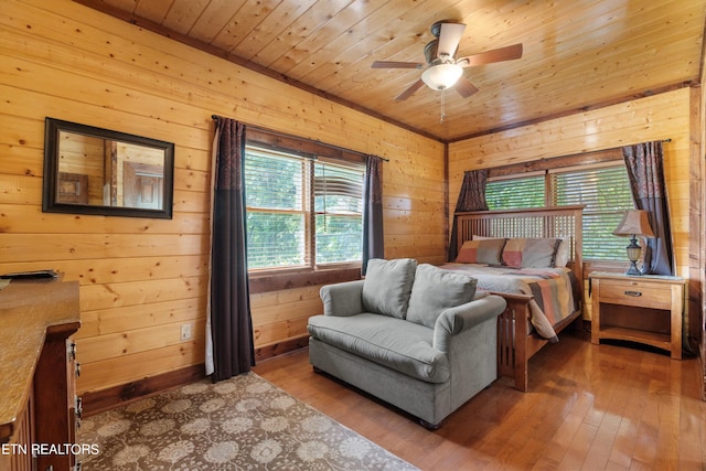 bedroom featuring multiple windows, wood walls, ceiling fan, and wood ceiling