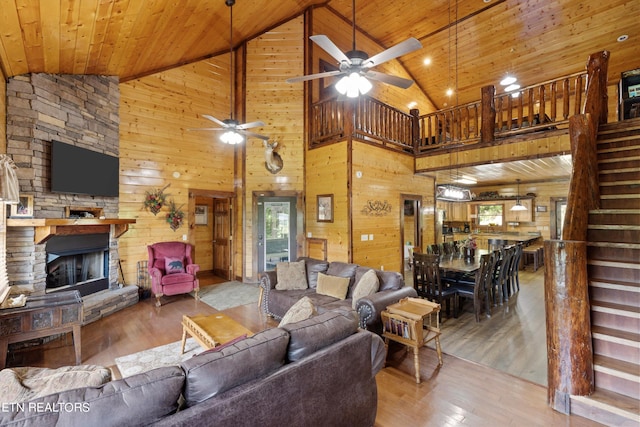 living room with wood-type flooring, wooden walls, high vaulted ceiling, and wooden ceiling